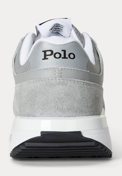 Baskets Polo grises et blanches vues de dos, avec des matériaux en suède et en mesh et une semelle épaisse noire et blanche.