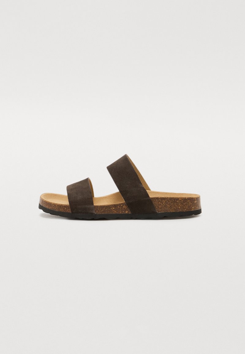 Brune semskede glidesandaler med to brede stropper, naturlig korkfotseng og teksturert gummisåle, som har et flatt, minimalistisk design.