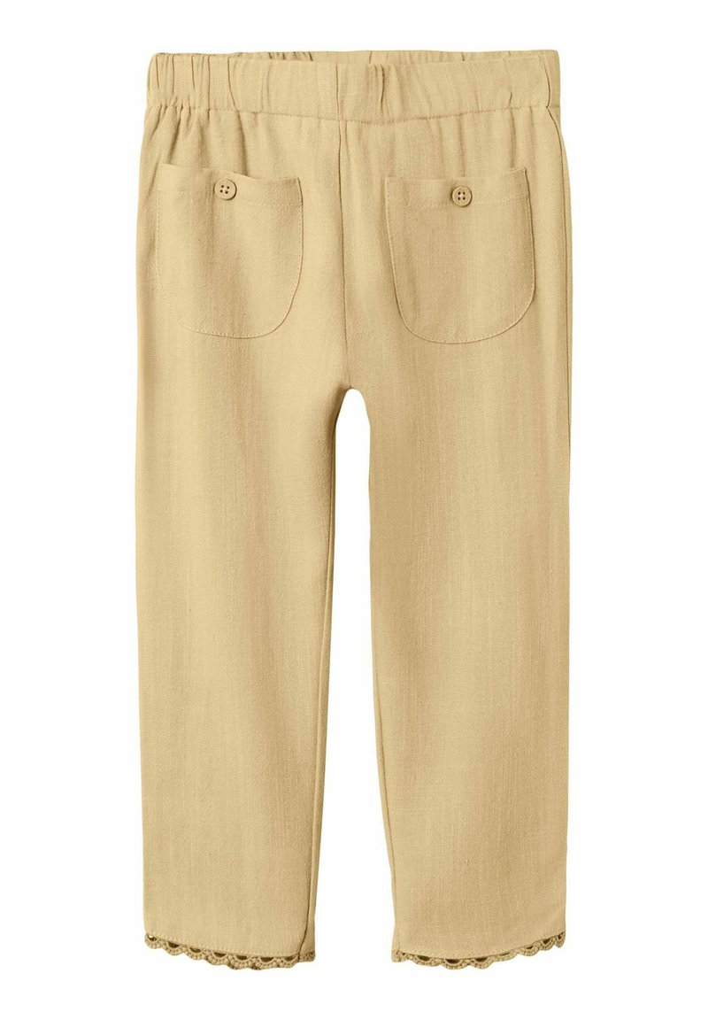 Beżowe bawełniane spodnie z elastycznym paskiem w talii, dwie tylne kieszenie z ozdobnymi guzikami i falbaniastym wykończeniem. Gładka faktura.