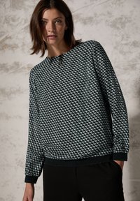 Felpa con motivo geometrico in bianco e nero, con scollatura rotonda, maniche lunghe e dettagli elastici sui polsini e sull'orlo.