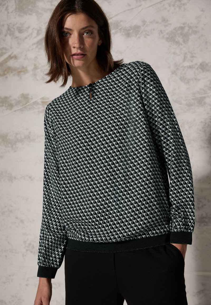 Felpa con motivo geometrico in bianco e nero, con scollatura rotonda, maniche lunghe e dettagli elastici sui polsini e sull'orlo.