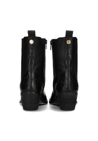 Botas de cuero negro hasta el tobillo con textura de cocodrilo, cremalleras laterales y un pequeño emblema dorado en la parte trasera; los tacones apilados aportan elevación.