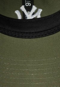 Olivgrüne Stoffmütze mit schwarzem Schirm, versehen mit weißem, gesticktem Logo auf der Vorderseite und sichtbarem Nähtextur, im Nahaufnahmen dargestellt.