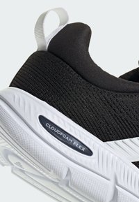 Zapatilla deportiva negra con parte superior de malla transpirable, mediasuela blanca, etiqueta "CLOUDFOAM FLEX" y suela de goma texturizada.