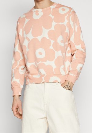 Felpa rosa chiaro con grandi motivi floreali bianchi, scollo rotondo, polsini e orlo a coste. Realizzata in tessuto morbido, presenta una vestibilità comoda.
