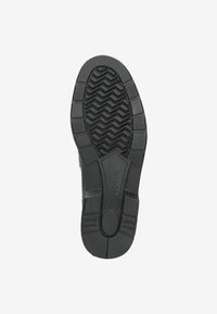 Suela de zapato de goma negra con un patrón texturizado que presenta surcos en zigzag y un diseño circular central para tracción y estabilidad.