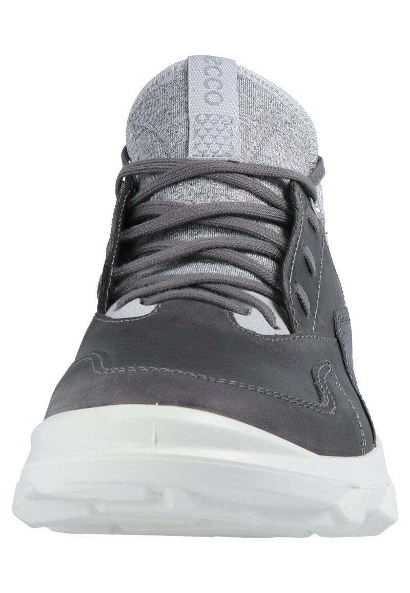 Baskets de sport grises avec une tige en cuir et maille, lacets plats, languette rembourrée et semelle en caoutchouc blanc avec une texture antidérapante.