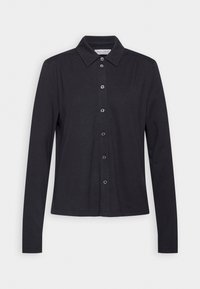 Chemise noire à manches longues avec boutons, col pointu, sept boutons et épaules légèrement froncées, présentée à plat sur fond blanc.