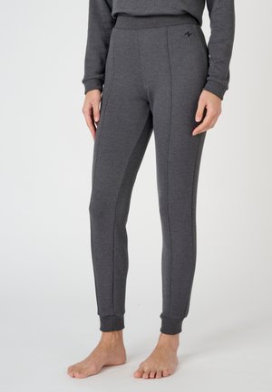 Leggings gris ajustés en matériau doux et extensible. Ils présentent une taille haute et des coutures latérales discrètes. Bords aux chevilles.