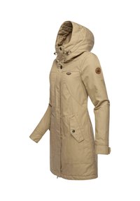 Beige lång kappa med huva, utrustad med dragkedjestängning, två framfickor och en rund logotypapplikation på vänstra ärmen. Texturerad tyg.
