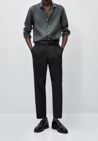 Dark gray button-up shirt in a lightweight fabric, paired with tailored black trousers and glossy black dress shoes. Simple, modern silhouette.