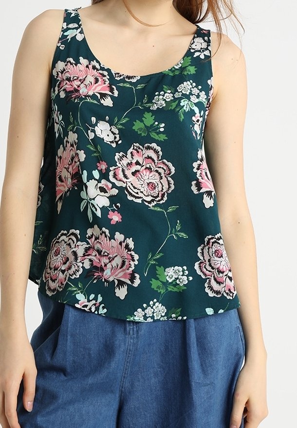 Débardeur floral en bleu canard foncé avec des fleurs rose et blanche. Tissu léger, décolleté en forme de scoop et coupe ample. Associé à un pantalon taille haute bleu.