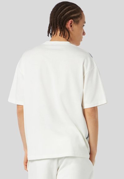 T-shirt bianco a maniche corte con taglio relaxed e scollo rotondo. Presenta una texture morbida e un branding discreto sulla spalla.