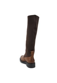 Knielange bruin leren en bruin gebreide combinatieboot met een ribbeltop, platte zool en een aantreklipje bij de hak voor makkelijk aan- en uittrekken.