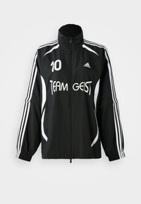 Černé sportovní sako s bílými pruhy, logo "TEAM GEIST" a číslo 10. Obsahuje vysoký límec a elastické manžety. Lehká tkanina.
