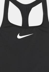 Zwarte sportieve tanktop met een racerback ontwerp, voorzien van een wit Nike swoosh logo op de voorkant. Soepele, rekbare stof.