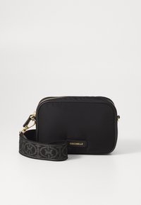 Borsa a tracolla nera in nylon con chiusura a zip e una tracolla testurizzata con logo. Presenta hardware dorato e una finitura morbida e liscia.