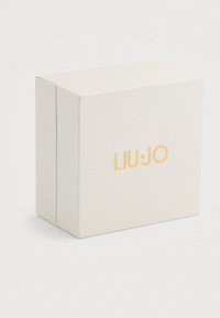 Fehér, textúrált, téglalap alakú doboz, amelynek közepén arany "LIU·JO" logó található, sima fehér háttér előtt.
