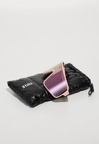 Ochelari de soare Bliz cu ramă roz și lentile cu gradient, așezați pe un pouch negru capitonat cu logo-ul brandului în alb.