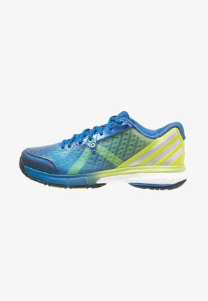 Chaussure de sport bleue et verte avec une tige en maille, un design texturé, des bandes réfléchissantes, un bout arrondi et une semelle blanche rembourrée.