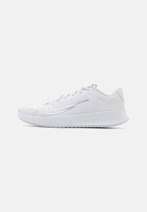 Chaussure de course Nike blanche basse avec tige en mesh, fermeture à lacets et semelle épaisse et rembourrée, vue de profil sur fond uni.
