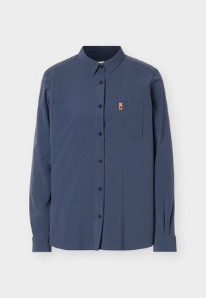 Langærmet mørkeblå skjorte med knapper og en enkelt brystlomme foran samt et lille lysebrunt mærke på lommens øverste kant.