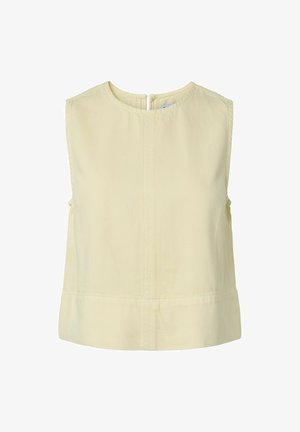 Ermeløs, lys beige croptop med rund hals og glidelås bak, med enkle sømdetaljer midt foran.