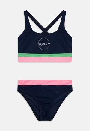 Navy blue swim top with crisscross straps and Roxy logo, featuring green and pink horizontal stripes. Matching bikini bottom with similar color scheme.