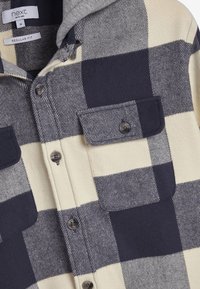 Flanellen overhemd met een grijs en crème ruitpatroon, voorzien van een knoopsluiting aan de voorkant, twee borstzakken en een grijze capuchon. Normale pasvorm.