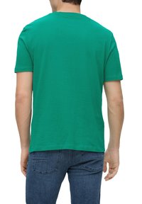 Groene katoenen T-shirt met een ronde hals en korte mouwen, met een gladde textuur en een standaard pasvorm, van achteren getoond.
