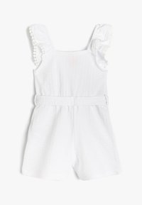 Witte romper van textuurstof, met gerimpelde mouwen met pomponbies en een cinched taille, geschikt voor warm weer.
