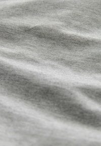 Light gray fabric with a soft texture, showing subtle wrinkles and a smooth surface. The material appears lightweight and slightly stretchable.