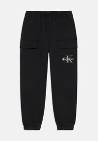 Pantalones jogger cargo negros con cintura y puños elásticos, bolsillos laterales con solapa y logo de Calvin Klein en el bolsillo del muslo derecho.