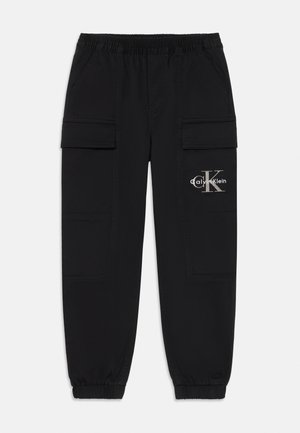 Crne cargo hlače s elastičnim pojasom i manžetama, bočnim preklopnim džepovima, i Calvin Klein logotipom na desnom džepu butine.