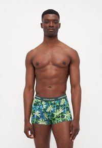 Bunte Herrenboxershorts mit einem grünen und blauen Palmenblatt-Muster, einem schwarzen Bund, der den Markennamen "BJÖRN BORG" zeigt.