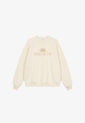 Kremkrāsas džemperis no mīksta auduma ar apaļu kakla izgriezumu, garām piedurknēm un centrālu saules grafiku ar tekstu "HARMONIJA".