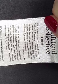 Clothing label showing brand name, production in Vietnam, and fabric composition listing 79% recycled polyester and 21% elastane.