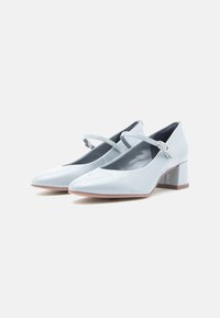 Escarpins Mary Jane en cuir verni bleu clair, avec un bout carré, une bride ajustable et un talon épais. Texture lisse et finition poli.