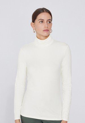 Krémový rolák s dlouhými rukávy, vyrobený z hladké, lehké látky. Má přiléhavý design a minimalistický styl.