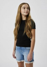Maglietta nera aderente a maniche corte abbinata a pantaloni corti in denim con bordo in pizzo, in un lavaggio azzurro chiaro.