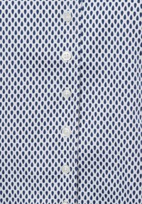 Witte shirt met een marineblauwe druppelpatroon, featuring zes knopen aan de voorkant. Gladde stof met een lichte glans.
