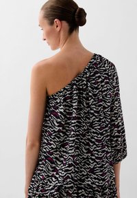 Top cu o singură umăr dintr-un material ușor, având un model de zebra în culorile negru, alb și roz, cu accente volan și o siluetă lejeră.