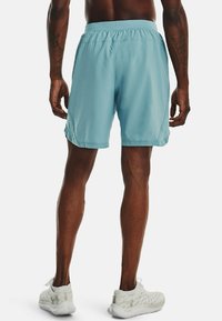 Vaaleansiniset urheilushortsit, jotka on valmistettu sileästä, kevyestä kankaasta. Shortsien vyötärö on elastinen ja sivuilla on verkkomateriaalista valmistetut paneelit hengittävyyden parantamiseksi.