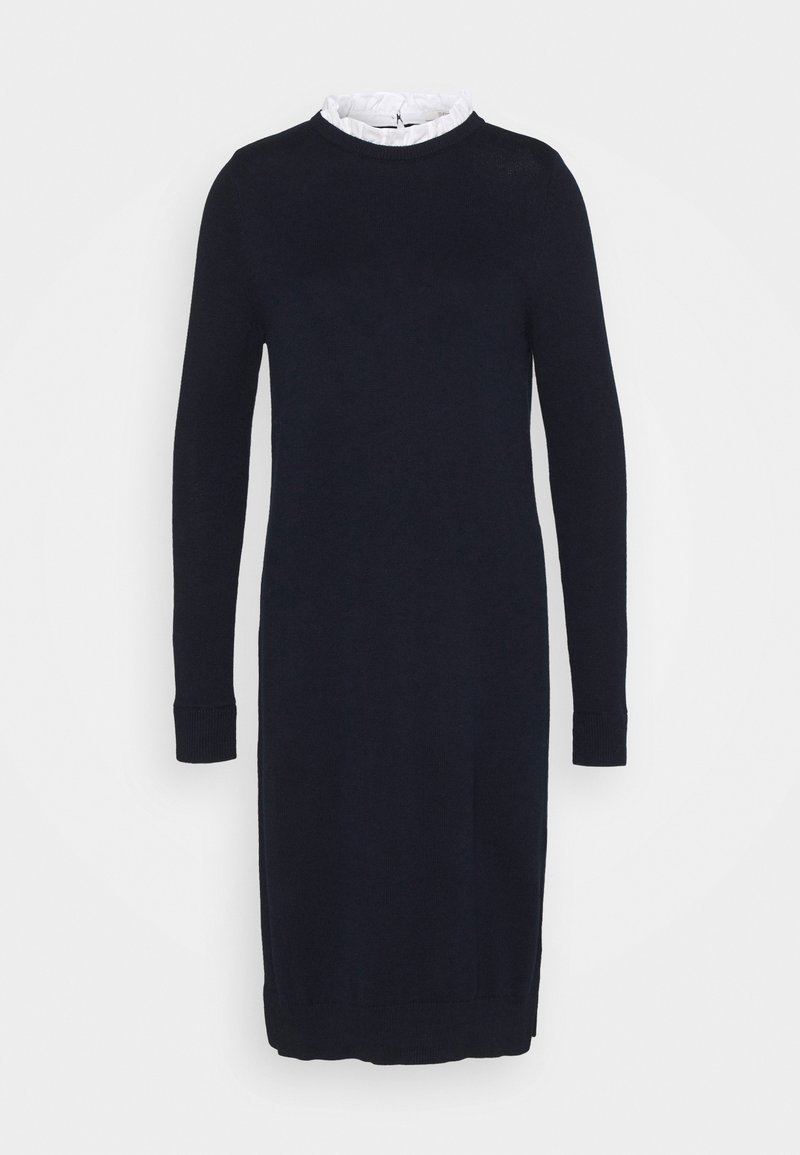 Robe bleu marine à manches longues avec une silhouette ajustée et un col blanc à volants au niveau de l’encolure.