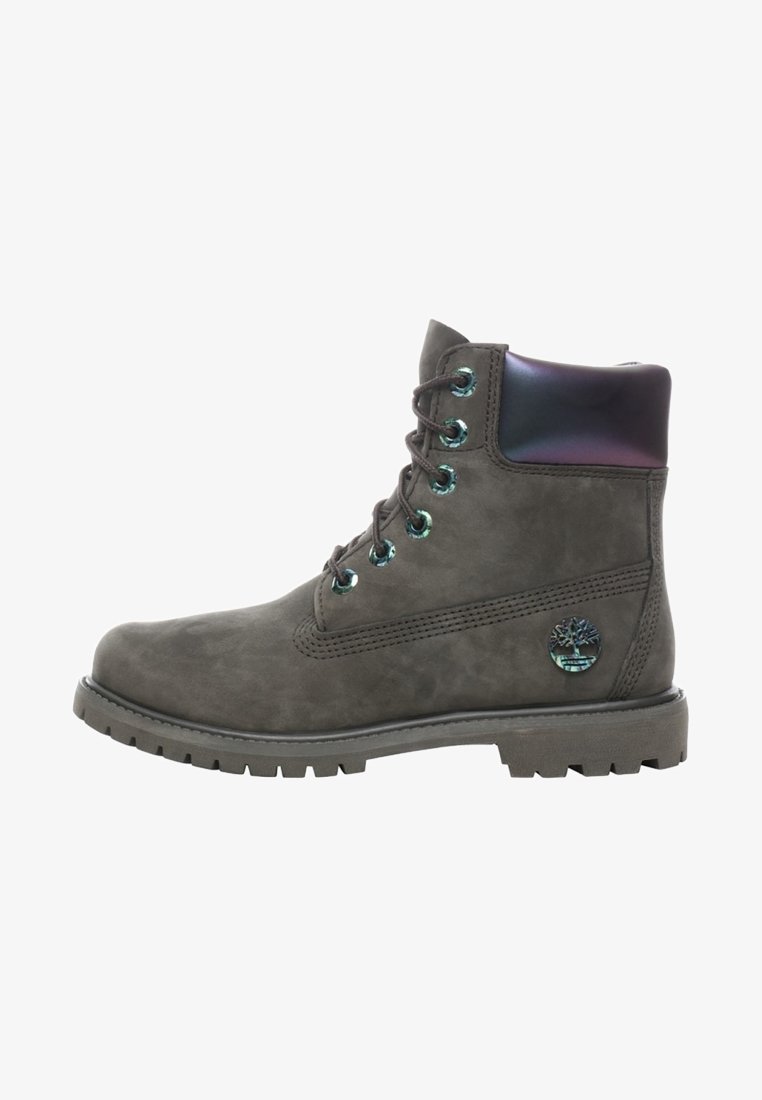 Botte grise en cuir à lacets avec semelle épaisse et col de cheville rembourré irisé, arborant un emblème rond du logo près du talon.