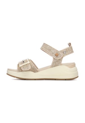 Sandalia de cuña beige con tiras tejidas, hebilla ajustable y suela de contraste; presenta parte superior texturizada y acolchado para mayor comodidad.