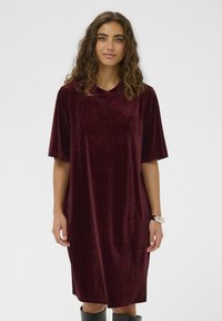 Rochie catifea bordeaux cu mâneci scurte, decolteu rotund și croi lejer. Textură netedă și design până la genunchi. Simplă și elegantă.