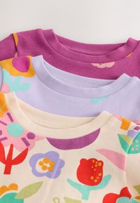 Satz von drei kurzärmligen Hemden: eines in Lila, eines in Lavendel und eines in Creme mit bunten Blumenmustern. Weicher Stoff mit gerippten Kragen.