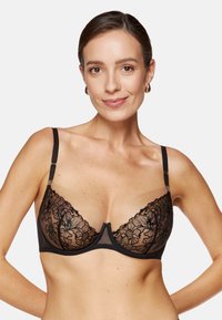 Czarny koronkowy biustonosz z kwiatową wyszywką, przezroczystymi miseczkami i cienkimi, regulowanymi ramiączkami. Posiada środkowy szew i subtelne ozdobne detale.