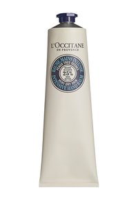 L'Occitane sheasmör handbalsam i en metallisk silverfärgad tub med en blå kork. Framsidan har en etikett som framhäver 25 % sheasmör.